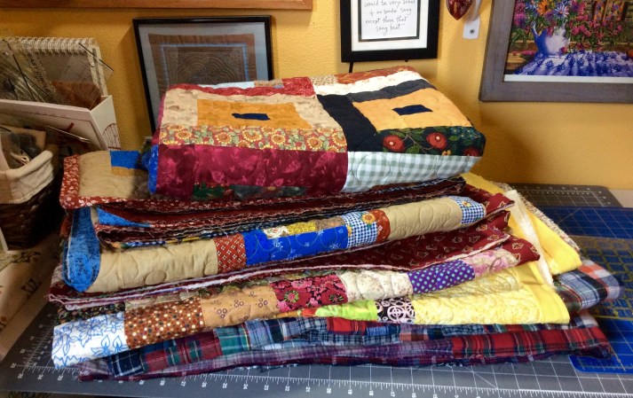 "Please complete us" (Pile-o-Quilts waiting for their bindings to be sewn down)